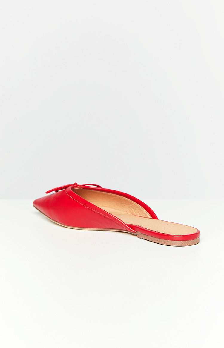 Side view of a red pointed-toe mule flat with a small bow detail and a flat sole
