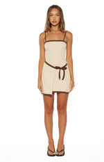 Front view of a cream mini dress with brown trim, square neckline, spaghetti straps, and a wrap tie waist