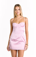 A close-up of a light pink satin mini-dress with thin spaghetti straps a sweetheart neckline and a lace trim on the cups. Our dress has visible seams on the bodice.