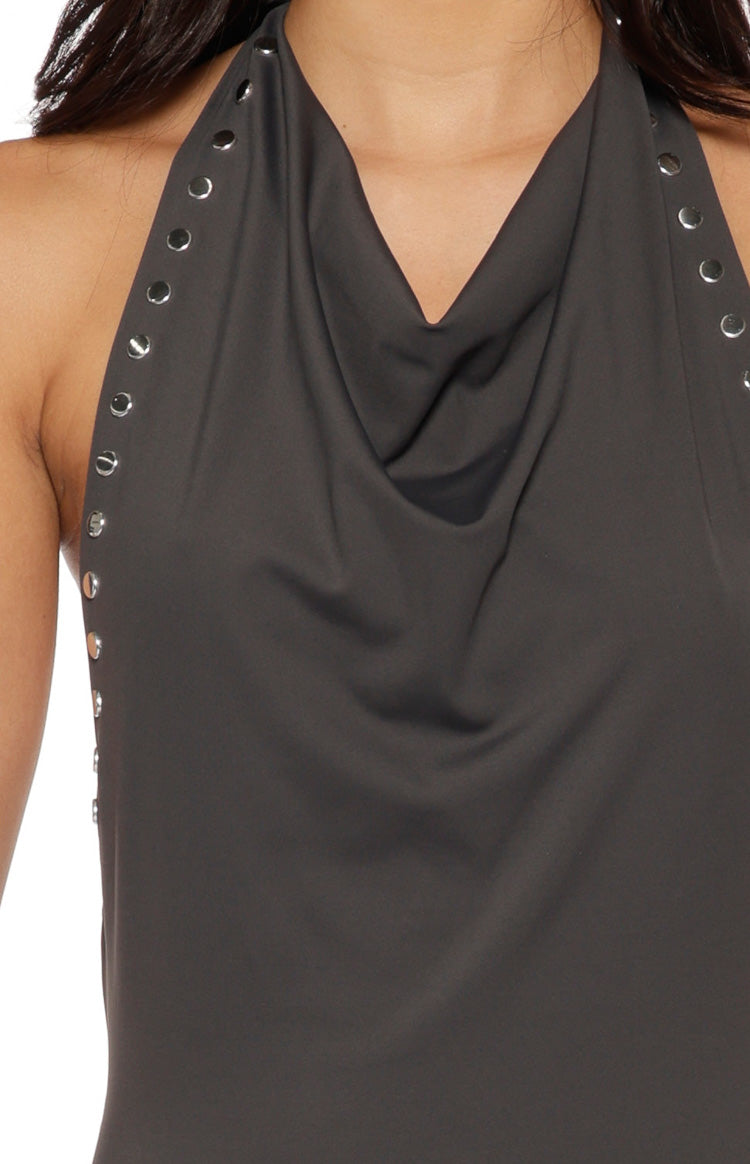 Close-up of the draped cowl neckline and silver stud embellishments on the shoulder strap of a grey maxi dress