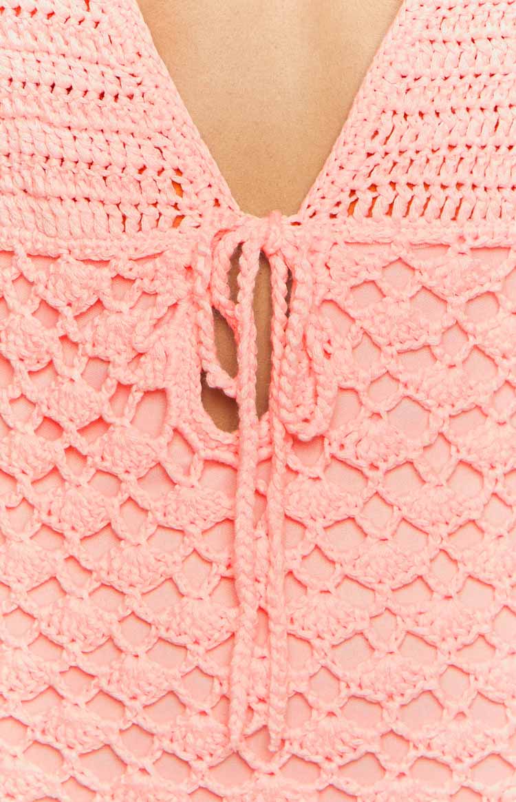 Close-up of the tulip pink crochet V-neckline with a tie detail and open knit pattern