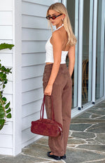 Rear side view of brown carrot fit jeans showing the high waist and back pocket stitching