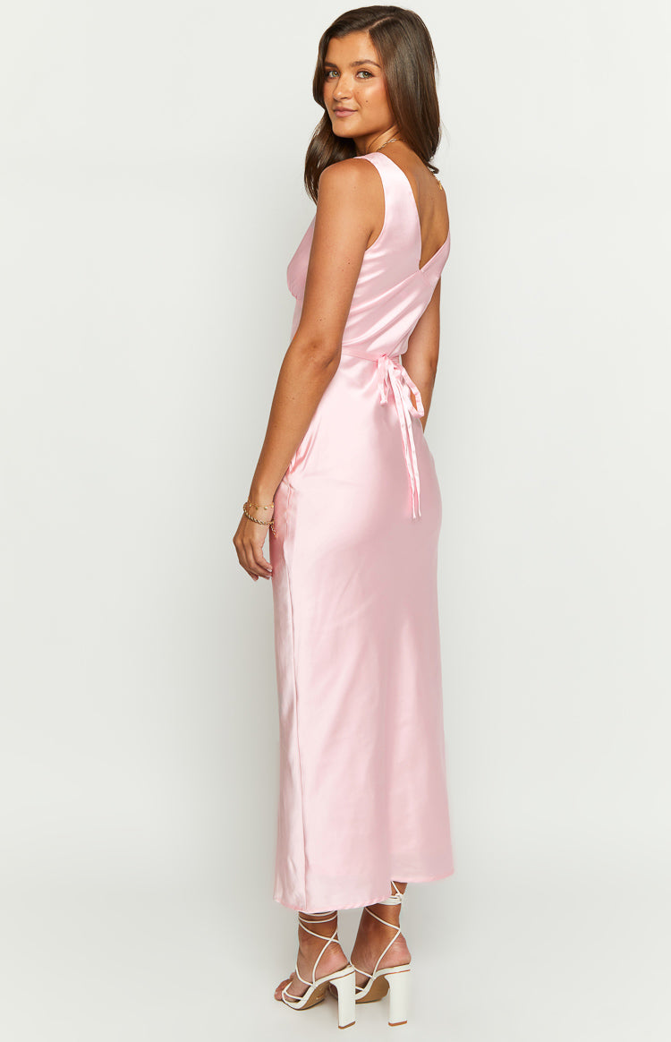 Side view of a pink satin maxi dress showing the back tie waist and flowing skirt