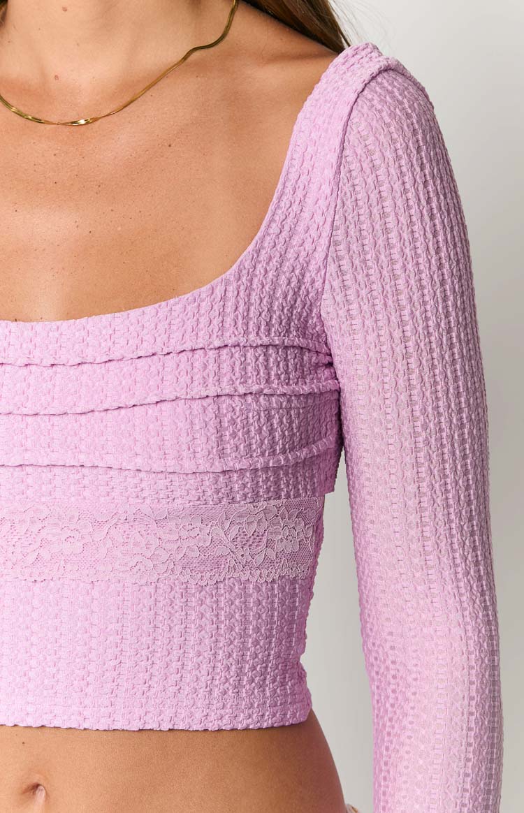 Close-up of the lilac long sleeve top showing the square neckline, textured knit fabric, horizontal ruched bands, and a lace trim