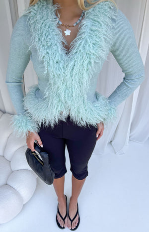 Mint green ribbed knit cardigan with shaggy fur trim around the V-neck, hem, and cuffs