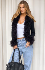 Black knit cardigan with shaggy fur trim on the open front and cuffs, cropped fit