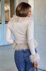 Rear view of a beige ribbed knit cardigan with shaggy fur trim on the collar, hem, and cuffs