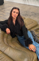 Black knit cardigan with shaggy fur trim on the V-neck and ribbed cuffs of the long sleeves