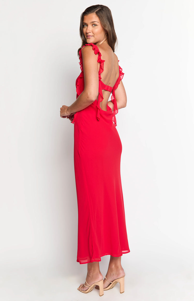 Side view of a red maxi dress with ruffled straps, an open back with ties, and a flowy skirt with a sheer hem