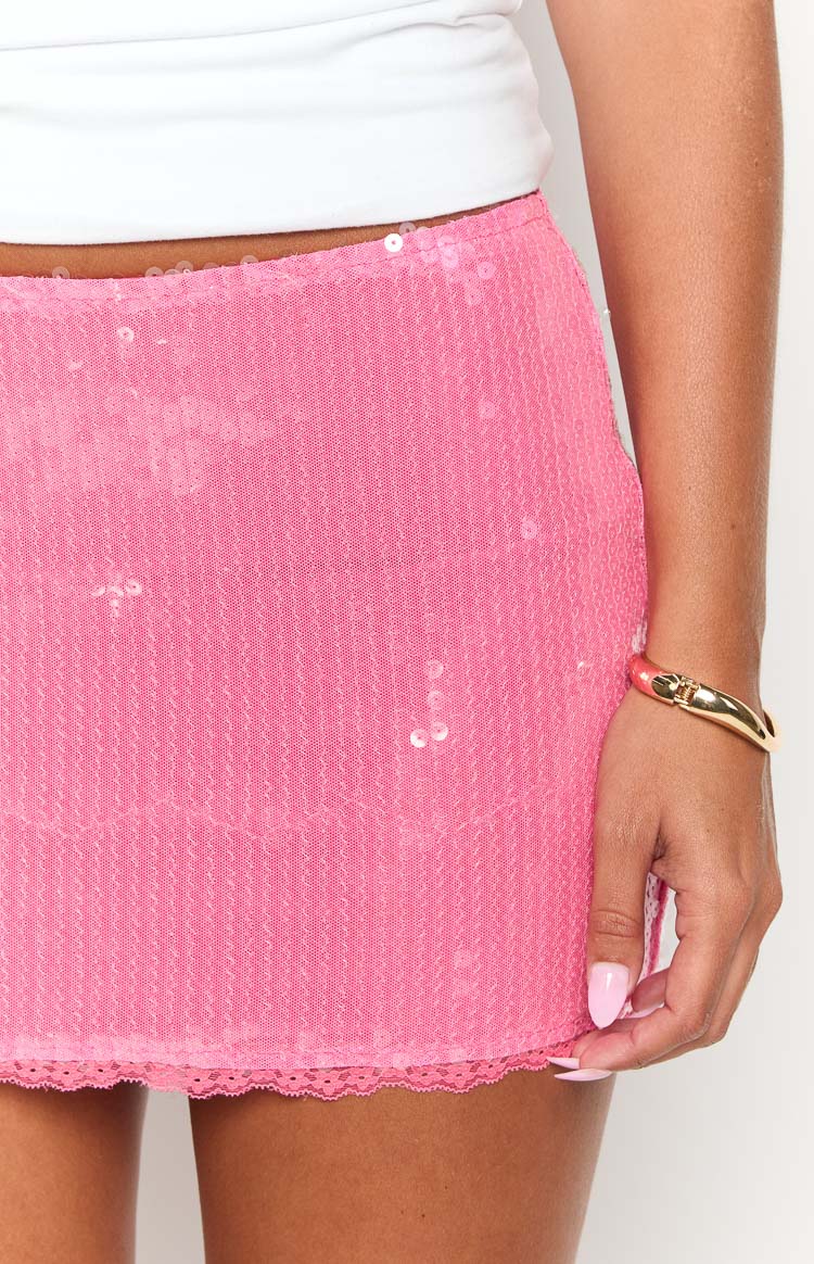Close-up of the pink sequin mini skirt showing the sequin texture and delicate lace trim at the hem