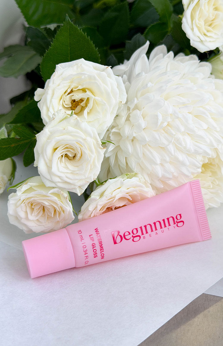 Beginning Boutique Watermelon Lip Gloss pink squeeze tube with 'Beginning Beauty' logo and product text