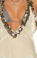 Close-up of the sheer white mini dress, showing the deep V-neckline and overlapping silver sequin trim