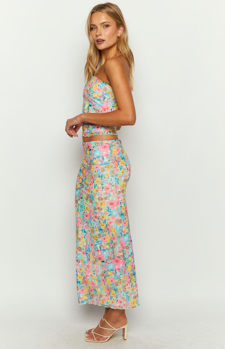 Side view of a multi floral maxi skirt, fitted through the hips with a flowing ankle-length hem in a lightweight fabric