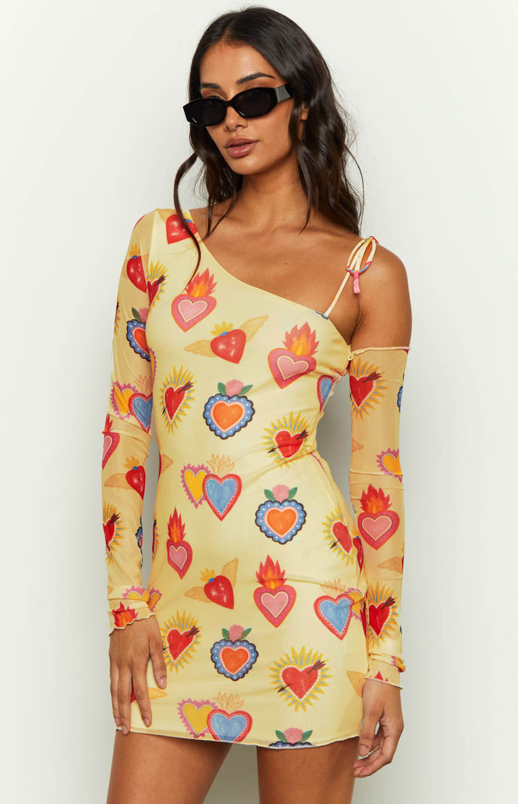 Close-up of a yellow mesh mini dress with colourful heart print, showing the one-shoulder neckline and tied spaghetti strap