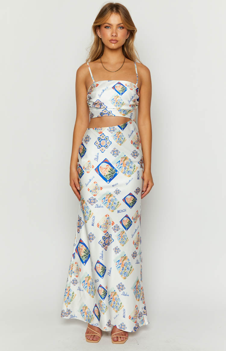 Front view of a white satin maxi dress with a cut-out waist and multi-coloured Italia print
