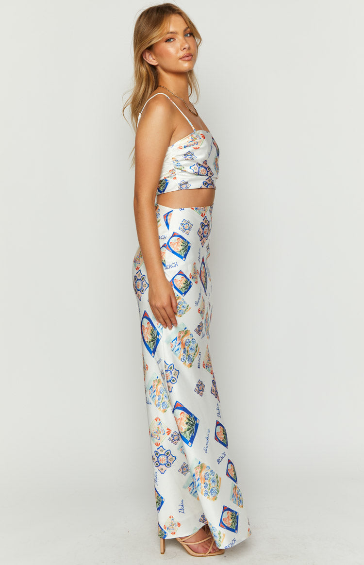 Side view of a white satin maxi dress with colourful Italia print, spaghetti straps, and waist cut-out