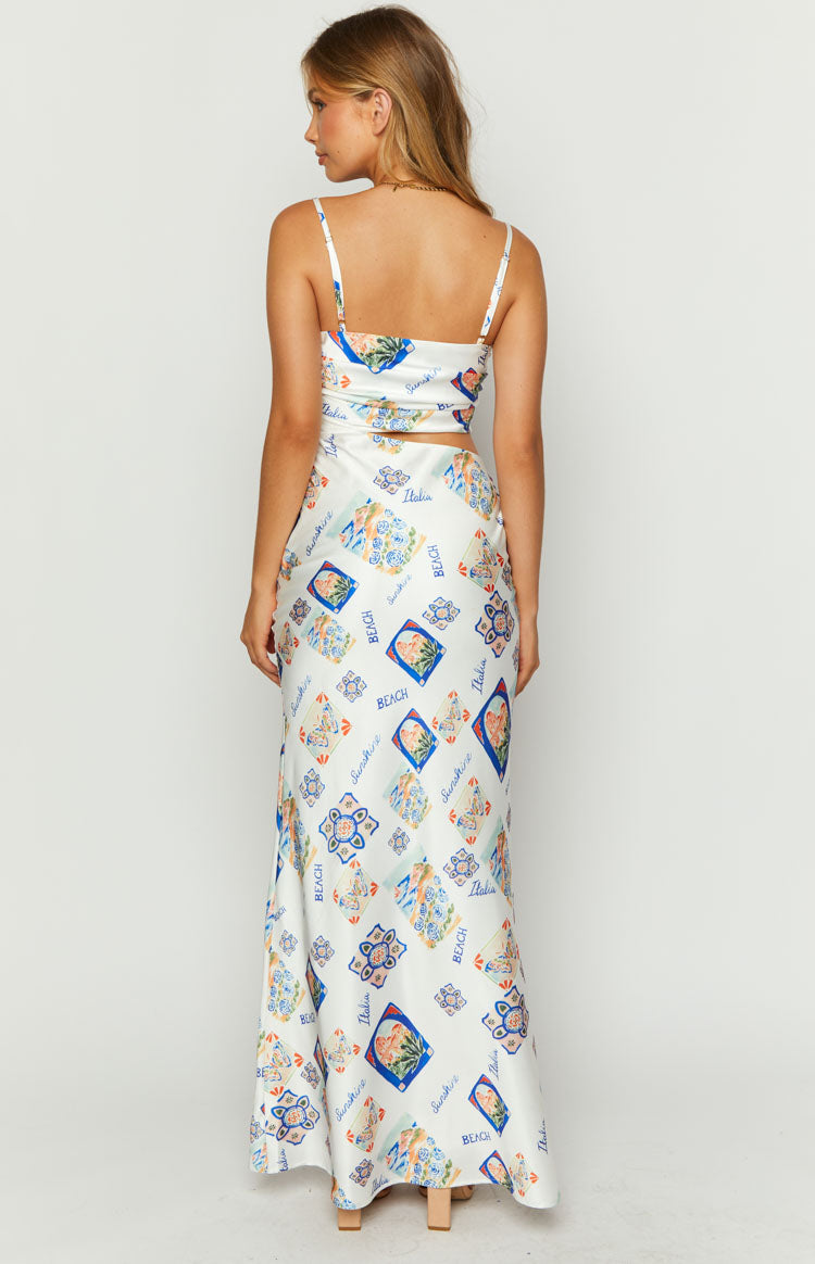 Rear view of a white satin Italia print maxi dress with thin spaghetti straps, square back, and waist cutout