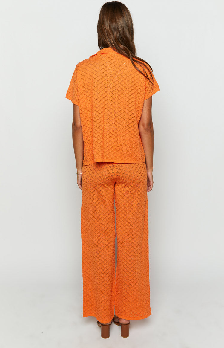Back view of orange wide-leg knit pants with a textured diamond pattern