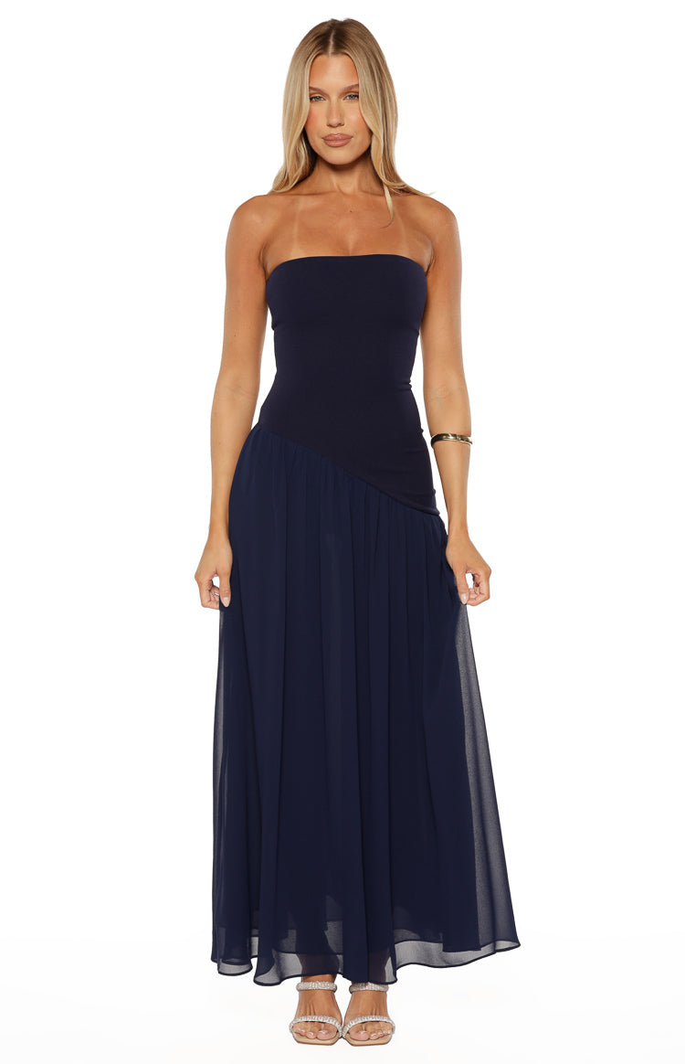 Navy strapless maxi dress with a fitted bodice and a flowy pleated chiffon skirt featuring a diagonal waist seam