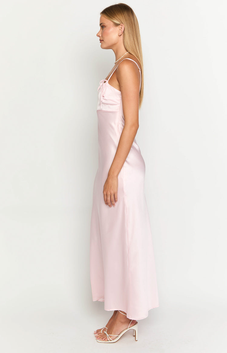 Side view of a light pink satin maxi dress with a tie-front bust detail and spaghetti straps