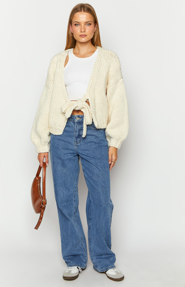 Front view of a cream chunky knit cardigan, cropped with a tie-up front and relaxed balloon sleeves