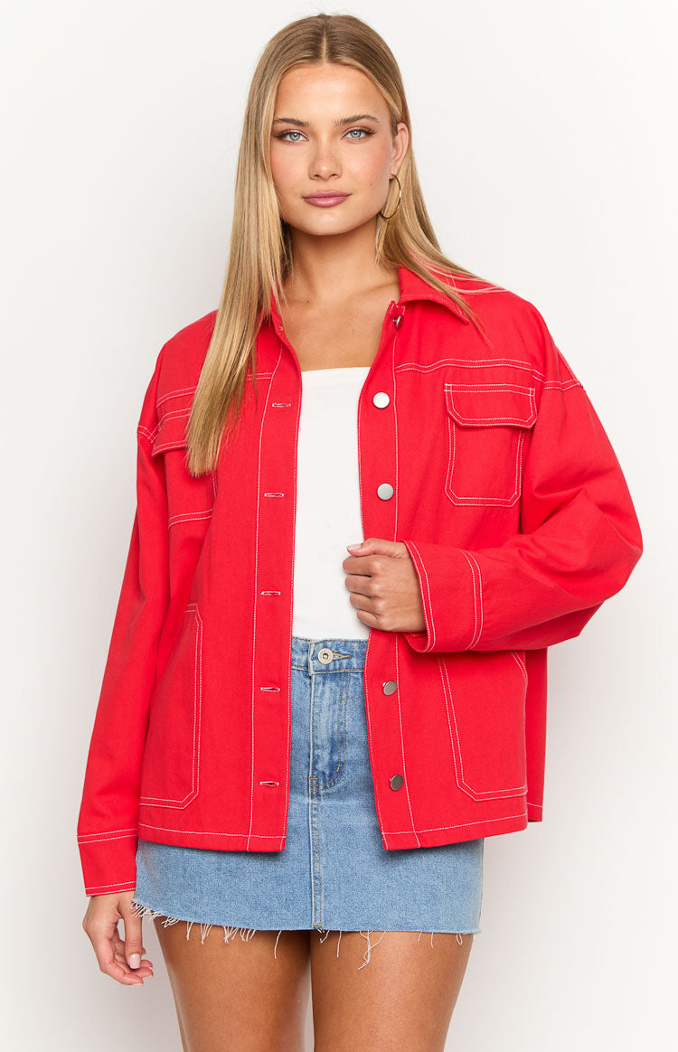 Front view of a red denim jacket with white contrast stitching, silver buttons, and flap chest pockets