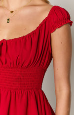 Close-up of the shirred elasticated waist and gathered bodice of a red playsuit