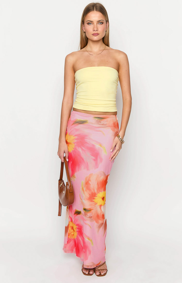 Pink maxi skirt with large red and yellow floral print and a flowy silhouette