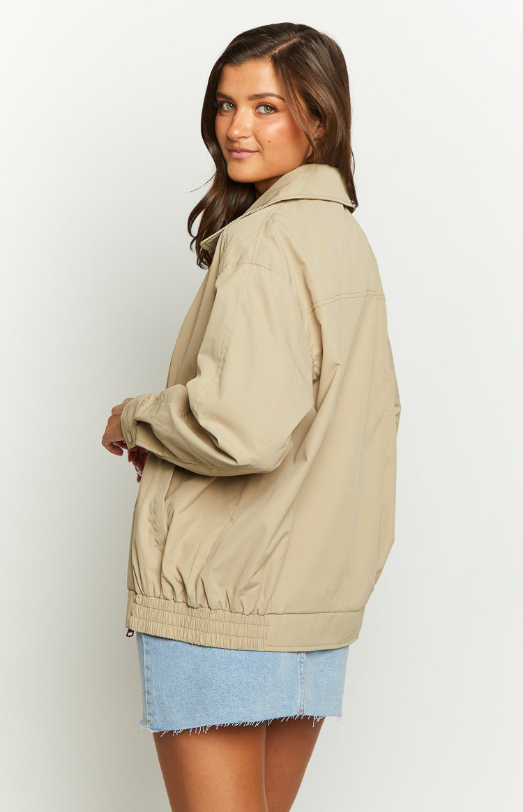 Side view of a fawn windbreaker bomber jacket with a relaxed fit, collared neckline, and elasticated hem
