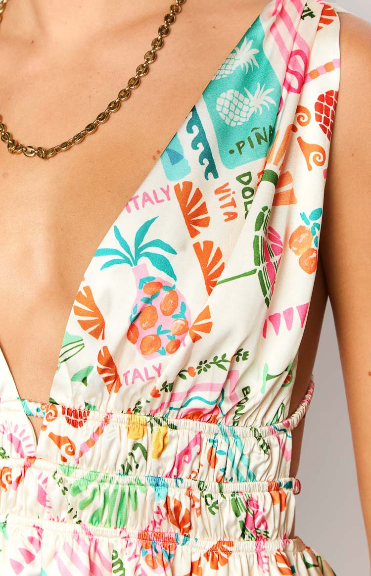 Close-up of the cream Dolce Vita print mini dress with pineapples, oranges, 'Italy' text, ruched elasticated waist and side cut-out