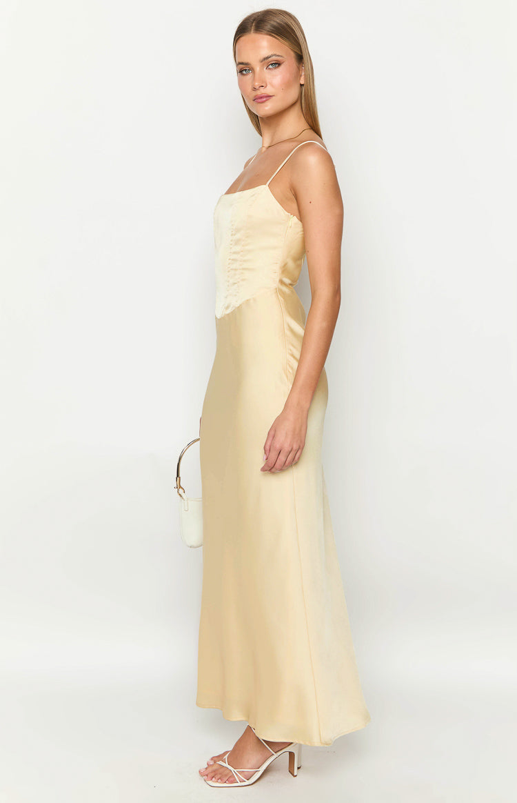Side view of a yellow satin maxi dress with a square neckline and corset-style bodice