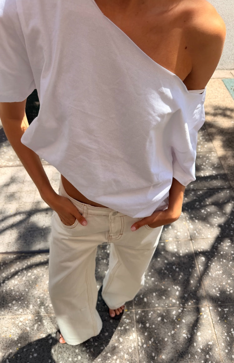 Overhead view of white low waist baggy leg jeans, showing the relaxed fit and contrast stitching