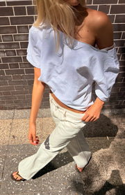 White low waist baggy leg jeans showing the relaxed fit, contrast stitching, and front pockets