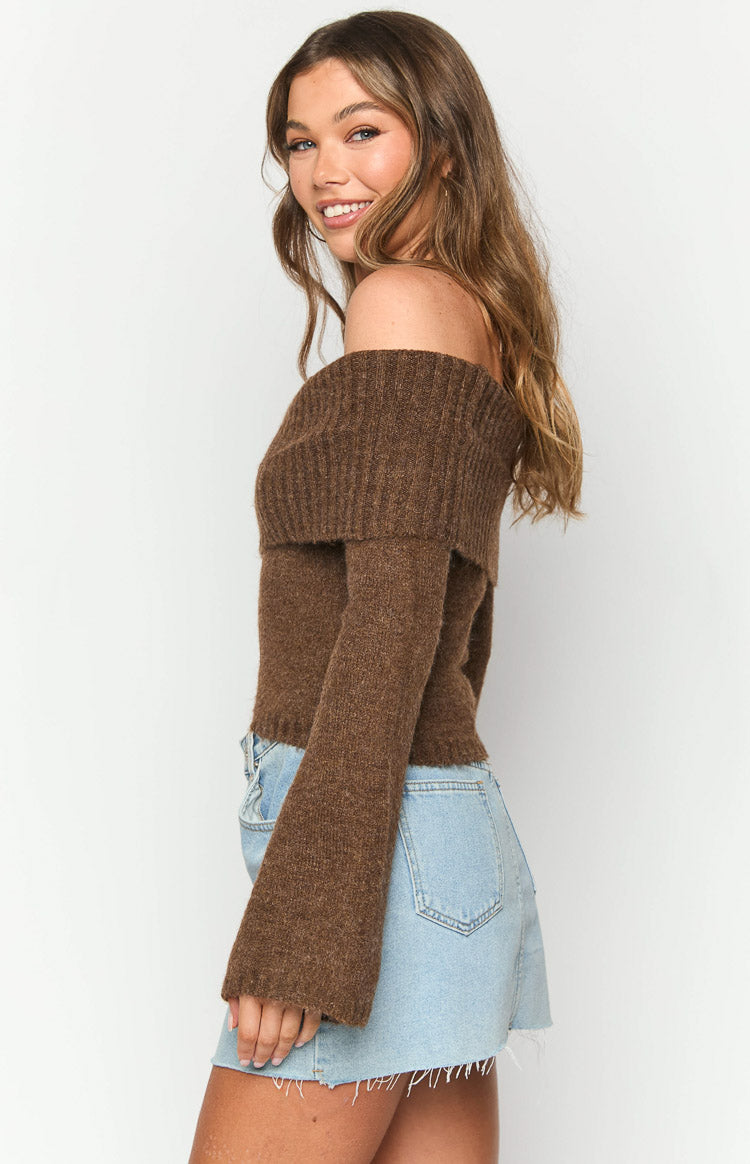 Side view of a brown off-shoulder sweater with a wide ribbed neckline and long flared sleeves