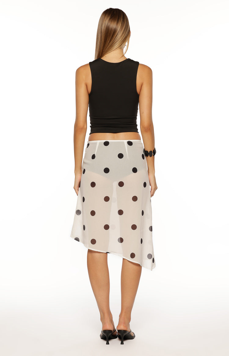 Rear view of the white sheer polka dot midi skirt with an asymmetrical hem