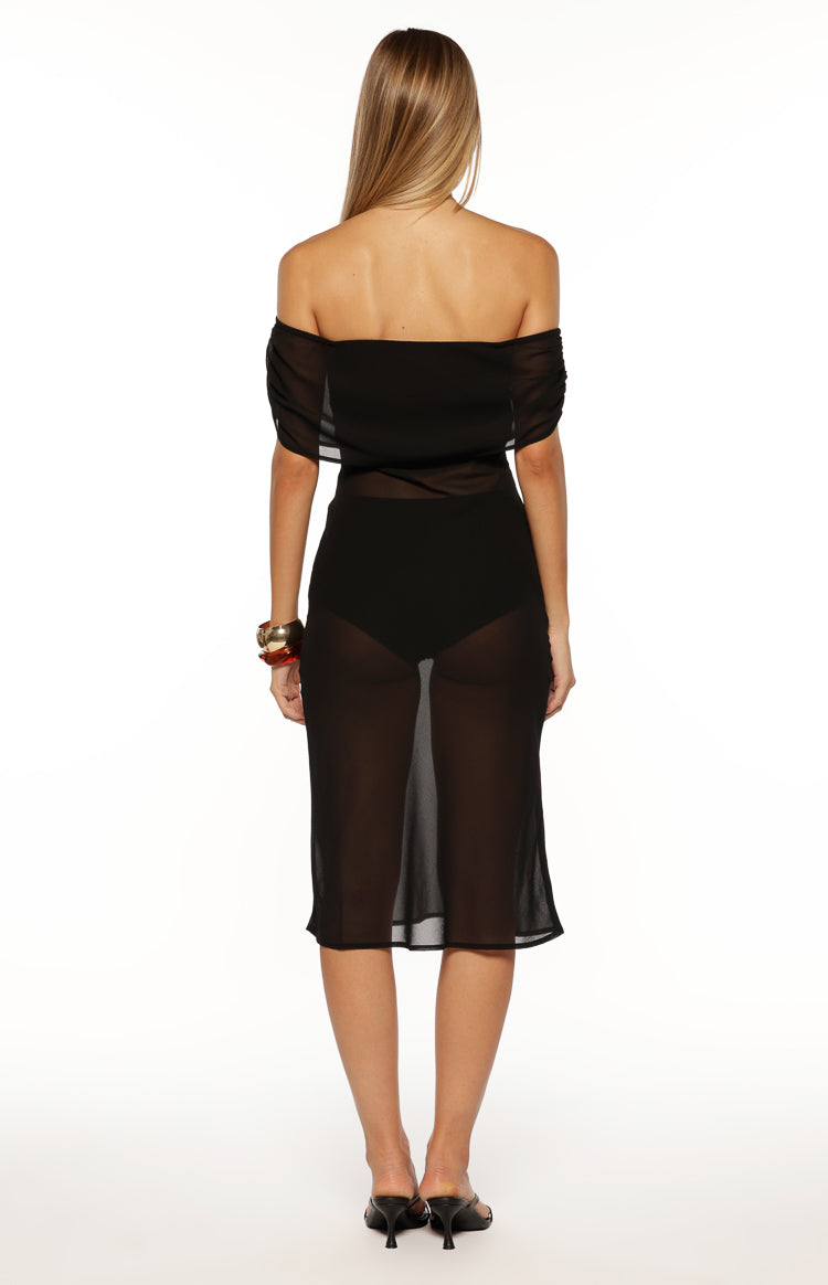 Rear view of a black sheer off-the-shoulder midi dress with gathered sleeves and visible undergarment