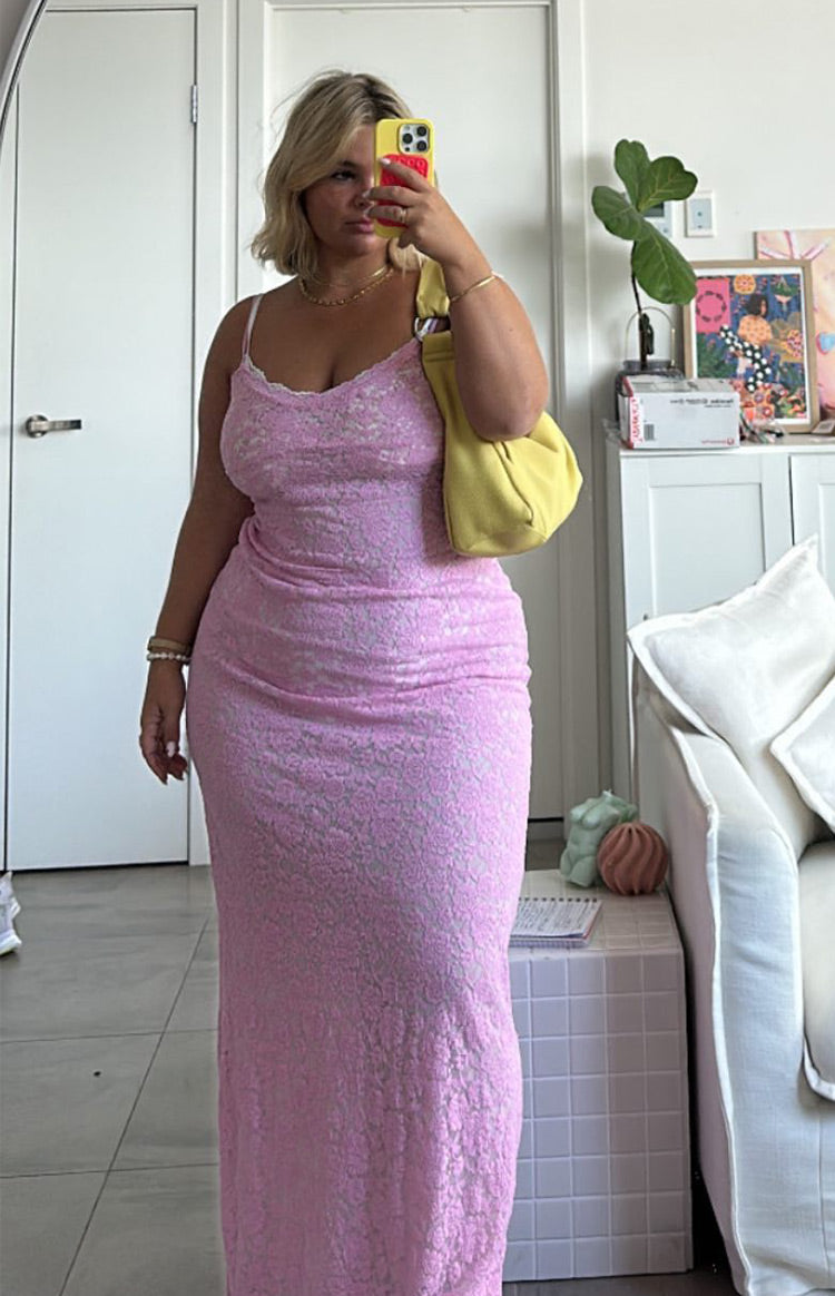 Full length view of a pink lace maxi dress with white lace trim on the V-neckline and spaghetti straps