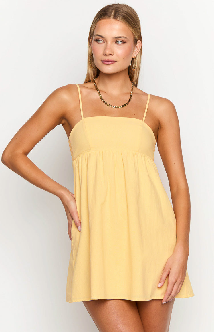 Yellow mini dress with a square neckline, thin spaghetti straps, and a gathered empire waist