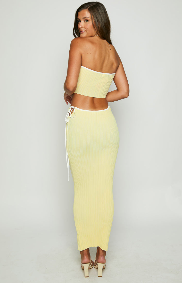 Rear view of a yellow ribbed knit tube top with white contrast binding along the top and bottom edges