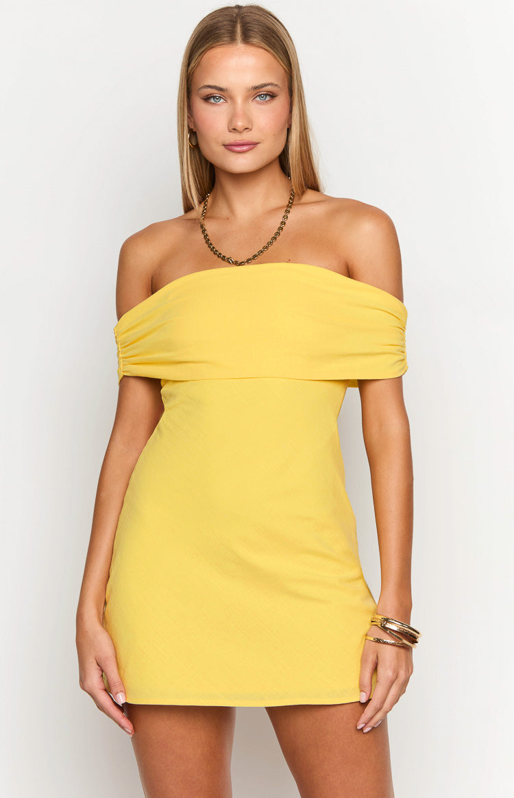 Front view of a primrose yellow off-the-shoulder mini dress with a gathered neckline and subtle textured fabric
