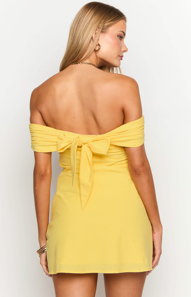 Rear view of a primrose yellow mini dress with a large bow tie-back detail and off-the-shoulder sleeves
