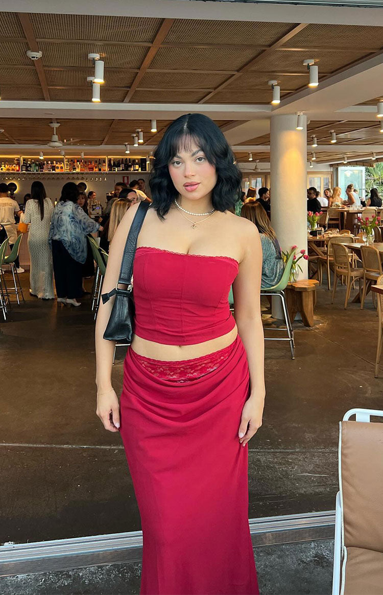 Crimson red maxi skirt with a low-rise draped waist and visible lace trim