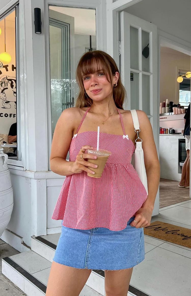 Red gingham halter top with a gathered peplum hem and small white bows on the bust