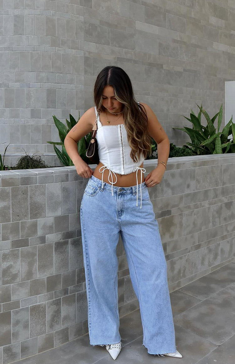 Light wash denim wide leg jeans with a low-rise fit and frayed hem