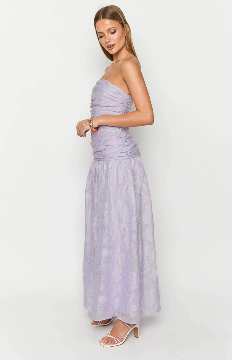 Side view of a lilac strapless maxi dress with a ruched bodice and a flowy textured maxi skirt