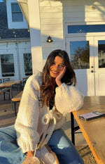 Cream chunky knit cardigan with a tie-up front and relaxed voluminous sleeves