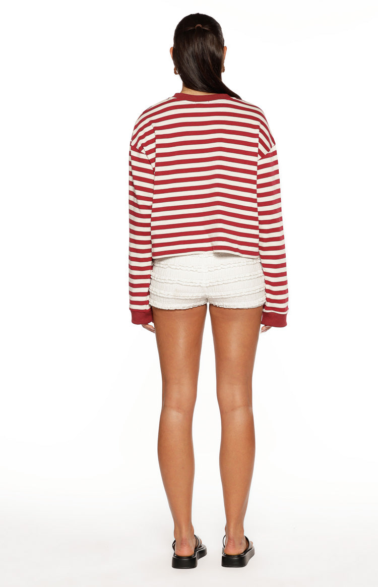 Rear view of a burgundy and white striped long sleeve top with a relaxed fit and slightly cropped hem