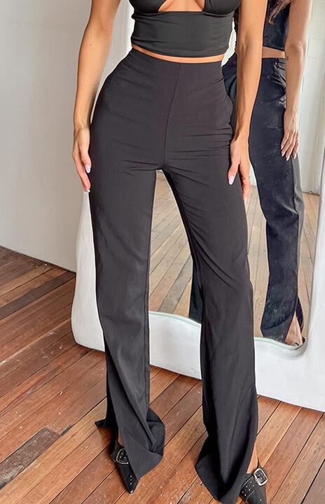 Front view of black high-waisted wide-leg pants with a split hem at the ankle