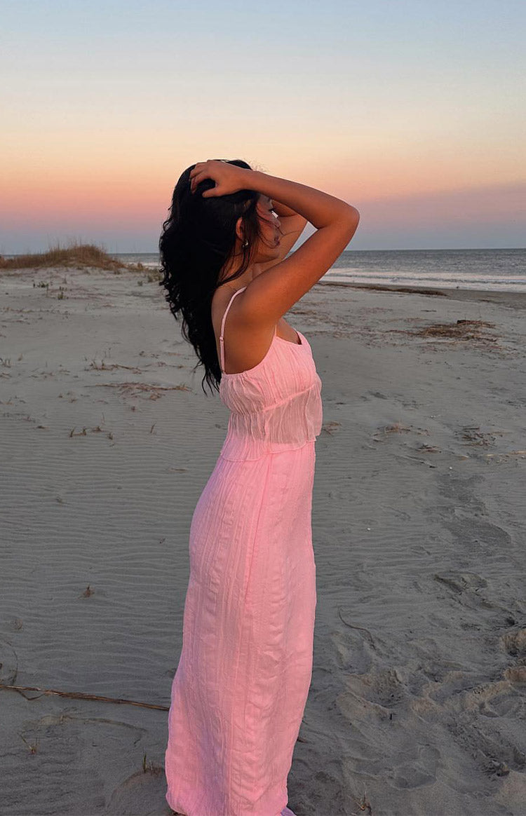 Side view of a pink maxi skirt with vertical crinkle texture and a fitted silhouette