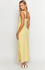 Side view of a yellow maxi dress with square back neckline, lace shoulder straps, and a side slit with lace trim